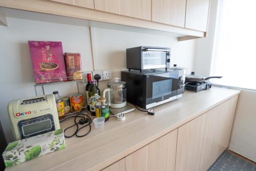 a kitchen counter with a microwave and a toaster oven at Aimelia guest house by G traveler in Petaling Jaya