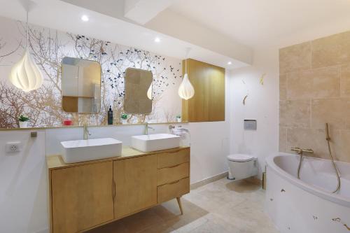 La salle de bains est pourvue de 2 lavabos, d'une baignoire et de toilettes. dans l'établissement Les suites de Montigny, à Aix-en-Provence