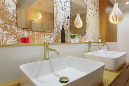 une salle de bain avec un lavabo blanc et un miroir dans l'établissement Les suites de Montigny, à Aix-en-Provence