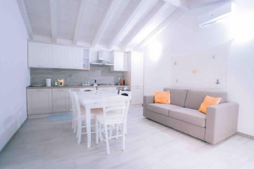 - une cuisine blanche avec une table et un canapé dans l'établissement Seaside Villa 2BR-1BA. 7 min walk to the beach, à La Caletta
