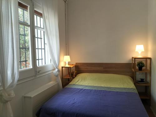 a bedroom with a bed and two windows at Casa Flor de Taronger in Viladecáns
