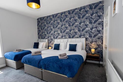 twee bedden in een hotelkamer met blauw en wit bij Free Parking Leisure Contractor Central in Rishton