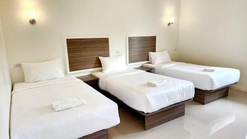a room with two beds with white sheets at ONE Chumphon Hotel in Chumphon