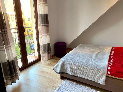 a bedroom with a bed and a large window at Piękny apartament z widokiem na Jezioro Niegocin in Giżycko