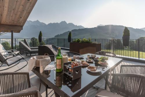 uma mesa com uma garrafa de vinho e pratos de comida em Biohof Ebengut em Maria Alm am Steinernen Meer