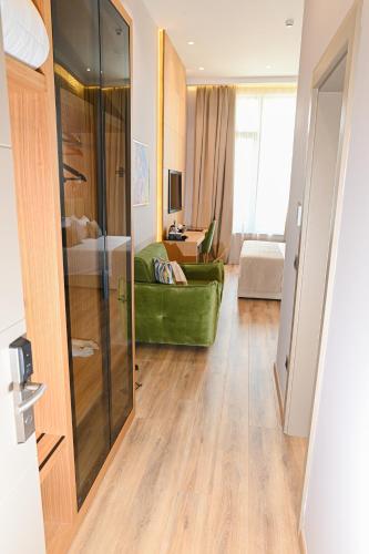a living room with a green couch in a room at White Hill Hotel, SPA & Conferences in Durrës