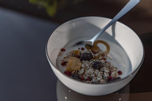 a white bowl filled with granola and a spoon at Biohof Ebengut in Maria Alm am Steinernen Meer