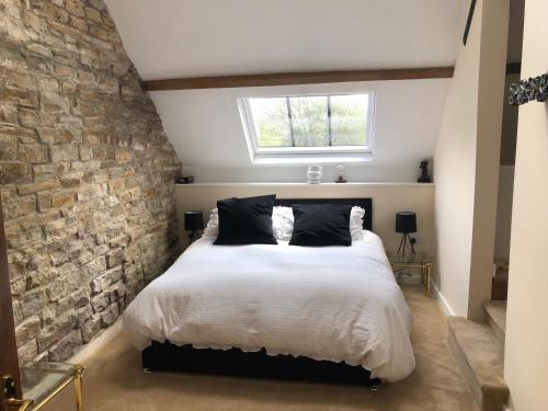 una camera con un grande letto con un muro di mattoni di Lanehead Old School a Lanehead
