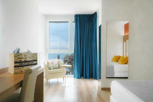 een slaapkamer met een bed, een stoel en een raam bij Kriss Internazionale Hotel in Bardolino