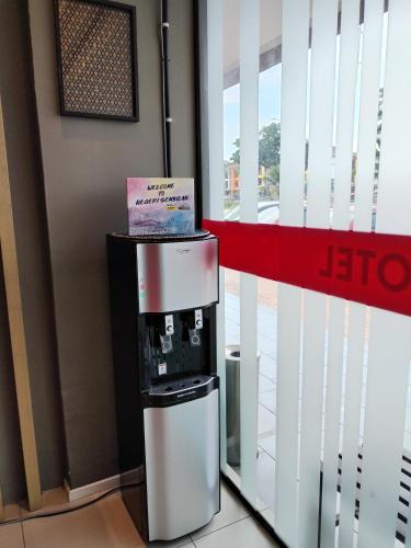 a coffee machine in a building with a sign on it at Win Win Boutique Hotel PD in Port Dickson