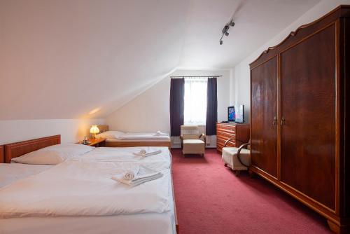 pokój hotelowy z 2 łóżkami i komodą w obiekcie Penzión a Reštaurácia Lavender w Popradzie