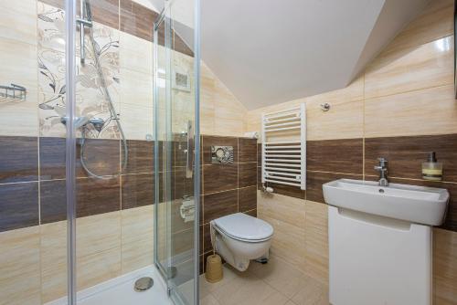 W łazience znajduje się toaleta, umywalka i prysznic. w obiekcie Penzión a Reštaurácia Lavender w Popradzie
