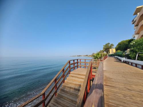 eine hölzerne Promenade, die zum Meer am Strand führt in der Unterkunft Playa bonita in Estepona