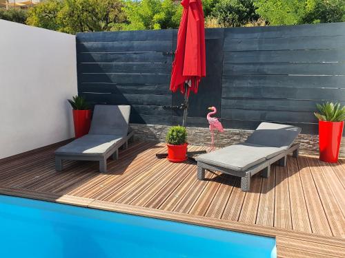 een patio met 2 stoelen en een flamingo op een terras bij The Love Room Marseille in Plan-de-Cuques