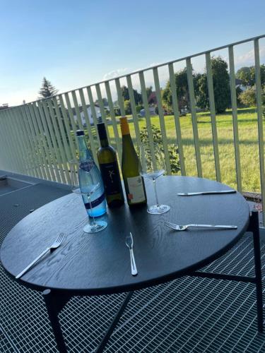 Chalet Park by Maier Höchst في هويست: طاولة مع زجاجات النبيذ والاكواب على شرفة