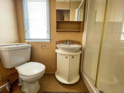een kleine badkamer met een toilet en een wastafel bij Lovely Caravan By The Beach In Pakefield, Suffolk Ref 68007cl in Lowestoft