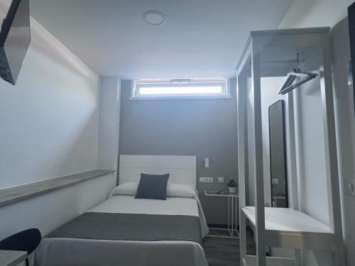 a small bedroom with a bed and a mirror at PENSION CASA JULIO ** in Culleredo