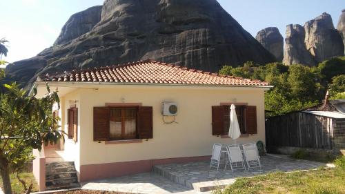 una casa con una montagna sullo sfondo di Genesis a Kastraki