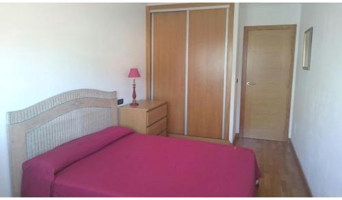 een slaapkamer met een bed met een roze deken bij A pie de playa de Ribeira in Ribeira