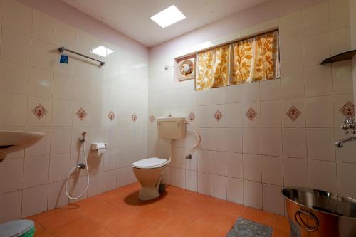 a bathroom with a toilet and a shower at Prakruthi Home Stay in Sollebail