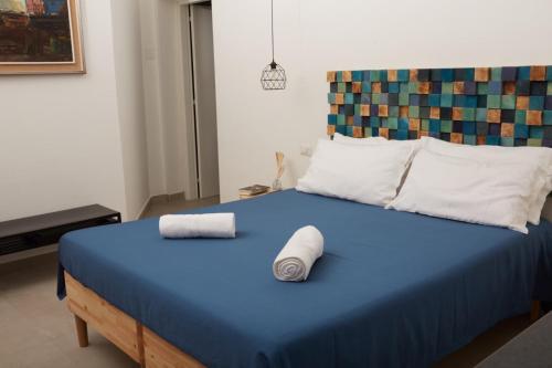 un letto blu con due cuscini sopra di B&B Miseno23 a Bacoli