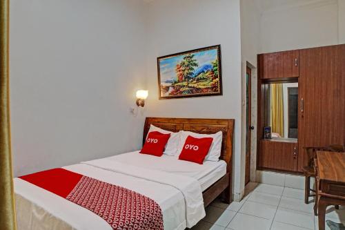 a bedroom with a bed with red pillows at OYO 92638 Jr Residence Syariah in Medan