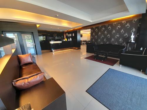 uma sala de estar com um sofá e um piano em Hotel De Leon em Lahad Datu