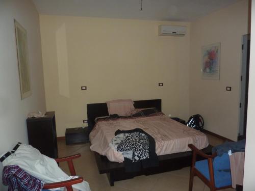 sypialnia z łóżkiem i 2 krzesłami w obiekcie Villa Halcyon cabo verde w mieście Cidade Velha