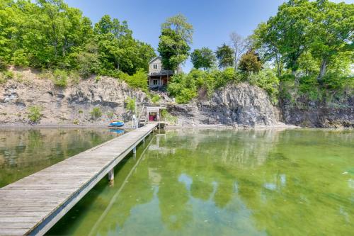 a dock in the water with a house in the background at Lockes Glen - Lakefront Geneva Getaway with Dock! in Geneva
