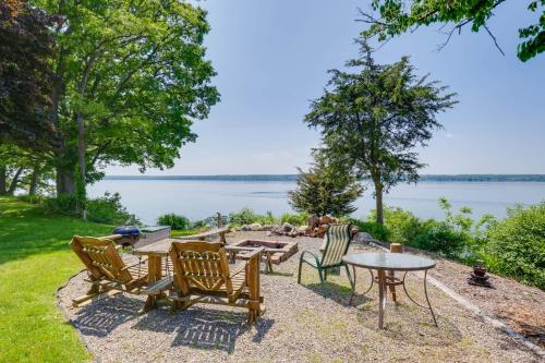 a patio with tables and chairs and a view of the water at Lockes Glen - Lakefront Geneva Getaway with Dock! in Geneva