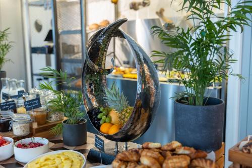 a buffet of food with fruit and plants on a table at Hotel Indigo Belgrade, an IHG Hotel in Belgrade