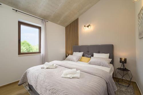 a bedroom with a large bed with two towels on it at Villa Laura Mia by IstriaLux in Juršići