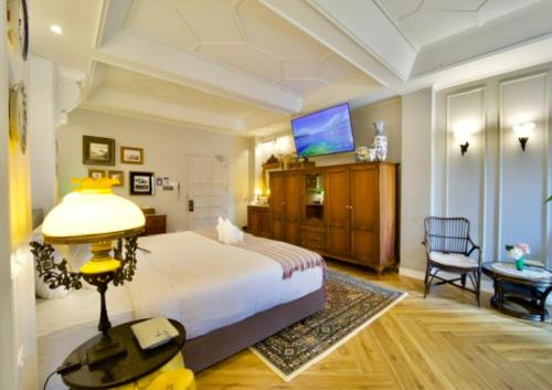 a hotel room with a bed and a tv at Yuu Hotel Ubon Ratchathani in Ubon Ratchathani