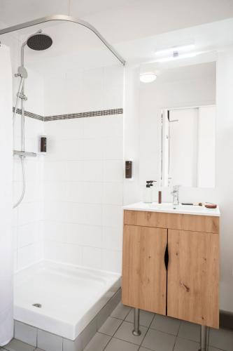 une salle de bain avec une baignoire, un lavabo et une douche dans l'établissement Séjours & Affaires Paris-Malakoff, à Malakoff