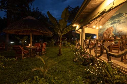 a patio with chairs and an umbrella at night at Africa Safari Arusha in Arusha