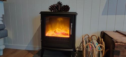 a black stove with a fire inside of it at Woodmans Cottage 24, Gold Coast Hinterland in Wongawallan