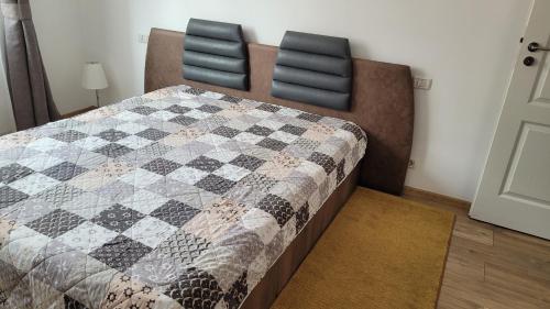 ママイア・ノルドにあるApartament Cristianのベッドルーム1室(ベッド1台、キルト、椅子2脚付)
