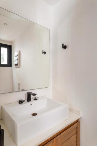 a bathroom with a white sink and a mirror at Casa Xaman in Tulum - TH 5 in Tulum