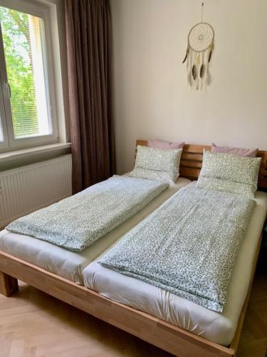 two beds sitting next to a window in a room at Apartmán Šnyt Primka in Olomouc