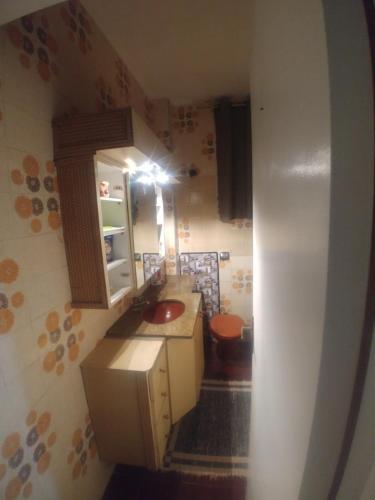 a small kitchen with a sink and a toilet at Sunset in Santos
