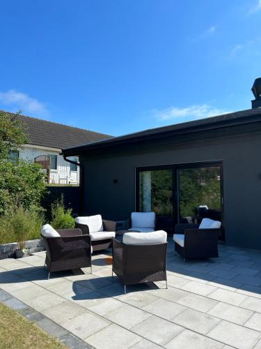 a patio with wicker chairs and furniture on a patio at Solstickan Hotell & Vandrarhem in Mellbystrand