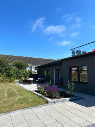 a house with a patio and a yard at Solstickan Hotell & Vandrarhem in Mellbystrand