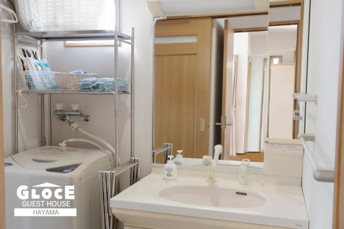 a bathroom with a sink and a mirror at GLOCE葉山サンセットハウスMORITO l バルコニーから葉山の海と町を一望 小型犬玄関と庭のみアクセス可 in Hayama