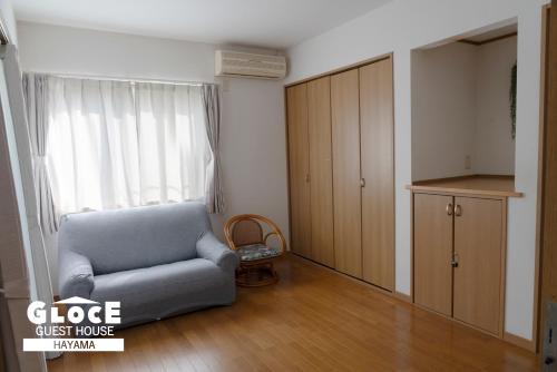 a living room with a couch and a cabinet at GLOCE葉山サンセットハウスMORITO l バルコニーから葉山の海と町を一望 小型犬玄関と庭のみアクセス可 in Hayama