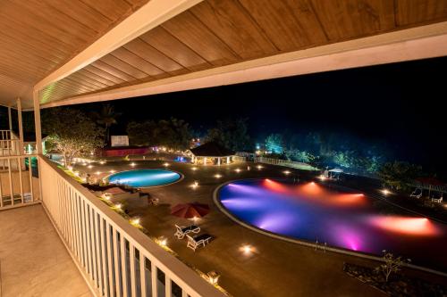 a view of a pool from a balcony at night at Urmilaa Green County Resort 35 KM From Kolhapur in Kolhapur
