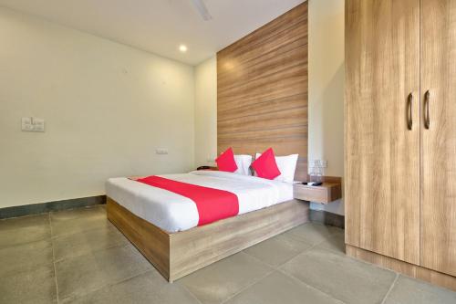 um quarto com uma cama grande e almofadas vermelhas em Blessings Residency em Rājpur