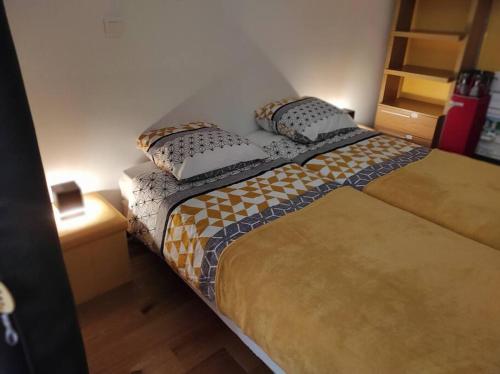 Una cama con dos almohadas encima en una habitación. en Chez Ghys, en Eaux-Bonnes
