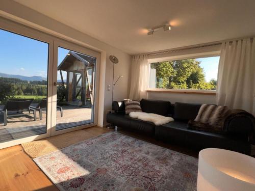 a living room with a couch and a large window at CR25 - more than a room in Immenstadt im Allgäu