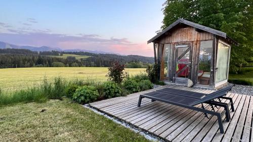 a small cabin with a bench on a wooden deck at CR25 - more than a room in Immenstadt im Allgäu