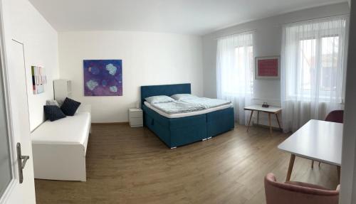 ein Schlafzimmer mit einem blauen Bett und einem weißen Sofa in der Unterkunft Art Apartment Telč in Telč